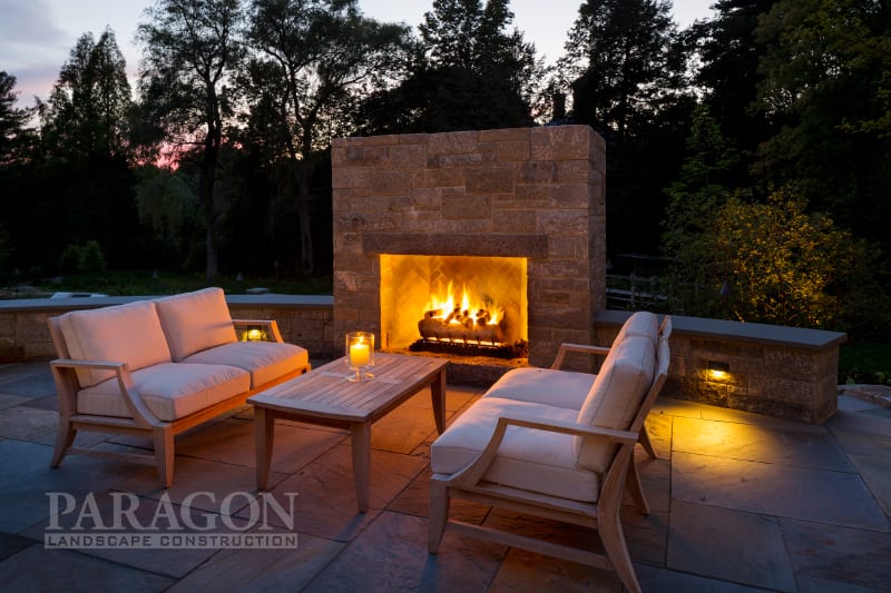 year-round backyard entertaining fireplace at night